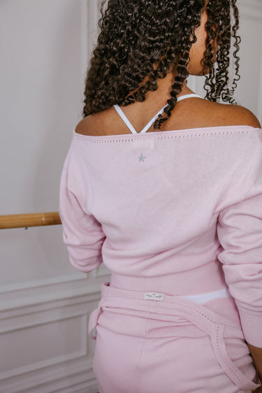Person wearing a pink Luna Luna top with thin straps over shoulders against a neutral background